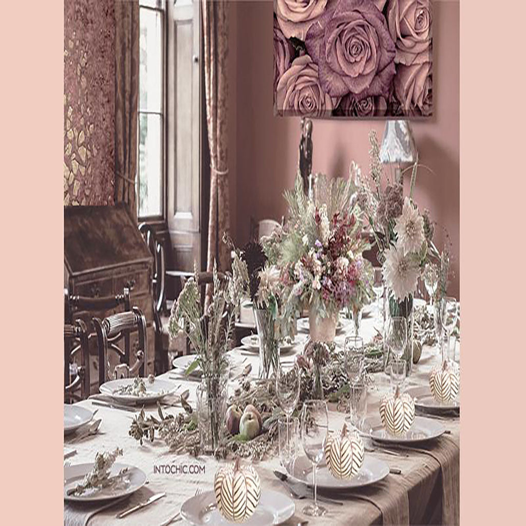 Holiday thanksgiving table. Ideas for a prepared set dinner for the holidays. Elegant and chic table seating. Floral center pieces, Nice home decor, wall roses frame, and white pumpkin decor table.